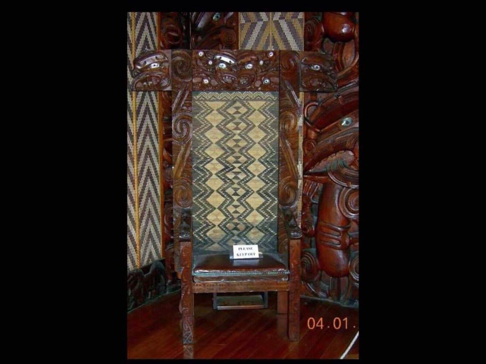 The carved chair with its tāniko panels