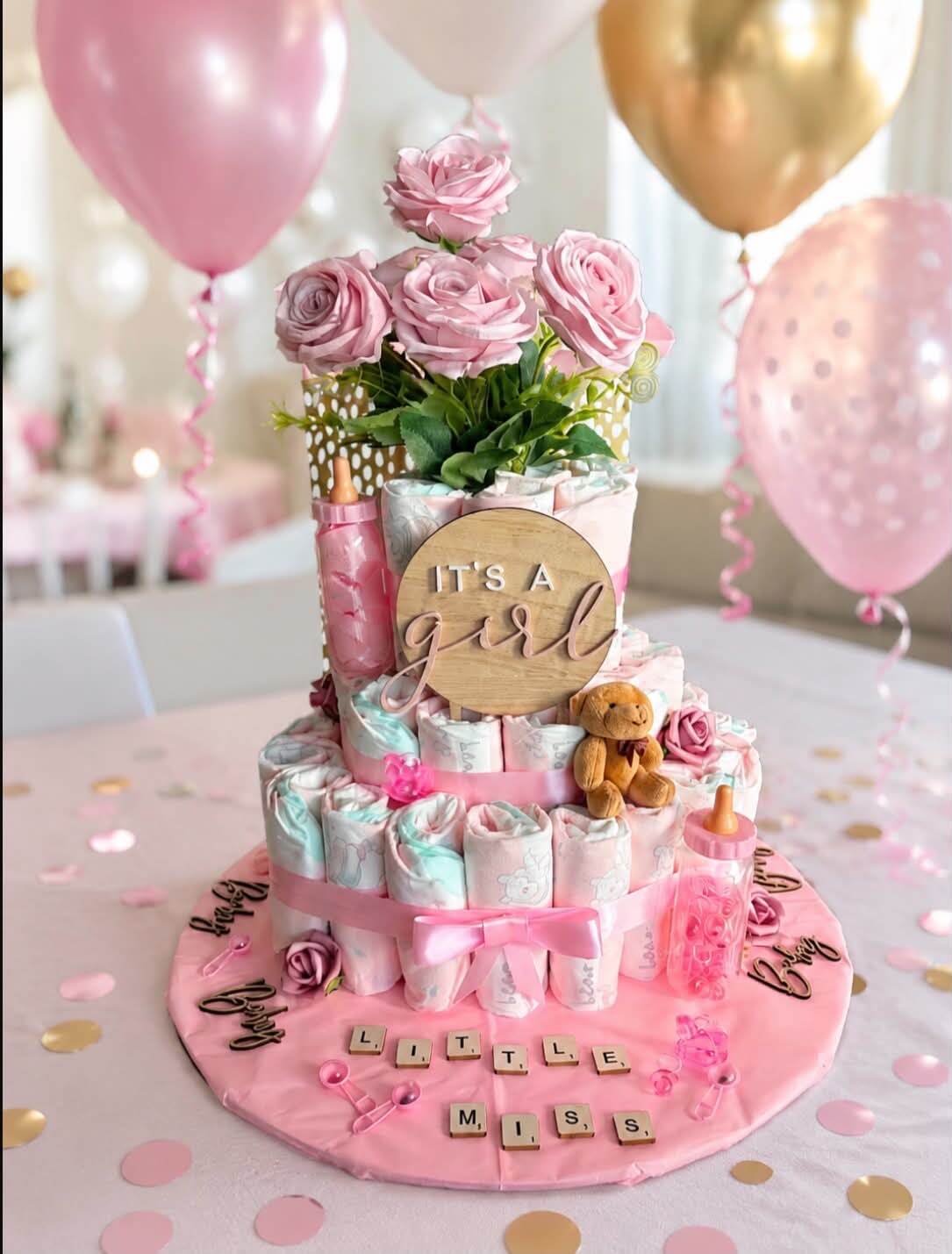 Honey's own photograph of her Little Miss nappy cake, two tiers with roses and an It's a Girl topper